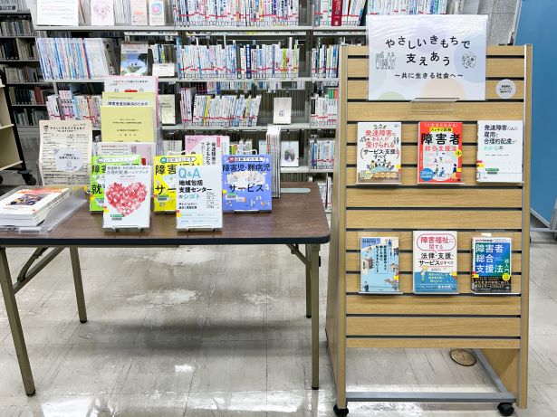 机やディスプレイだなに並べられた関連書籍や資料の写真